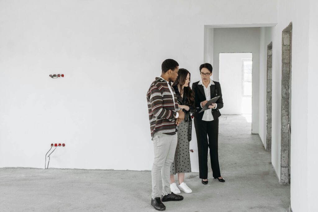 pexels-photo-7937327-7937327 A couple and realtor discuss details in an unfinished property. Ideal for real estate themes.